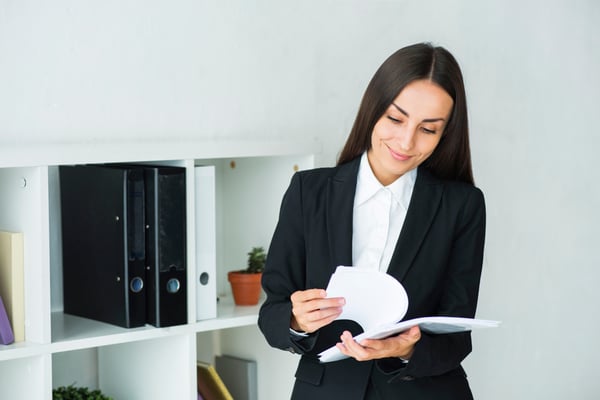 young-businesswoman-examining-documents-office